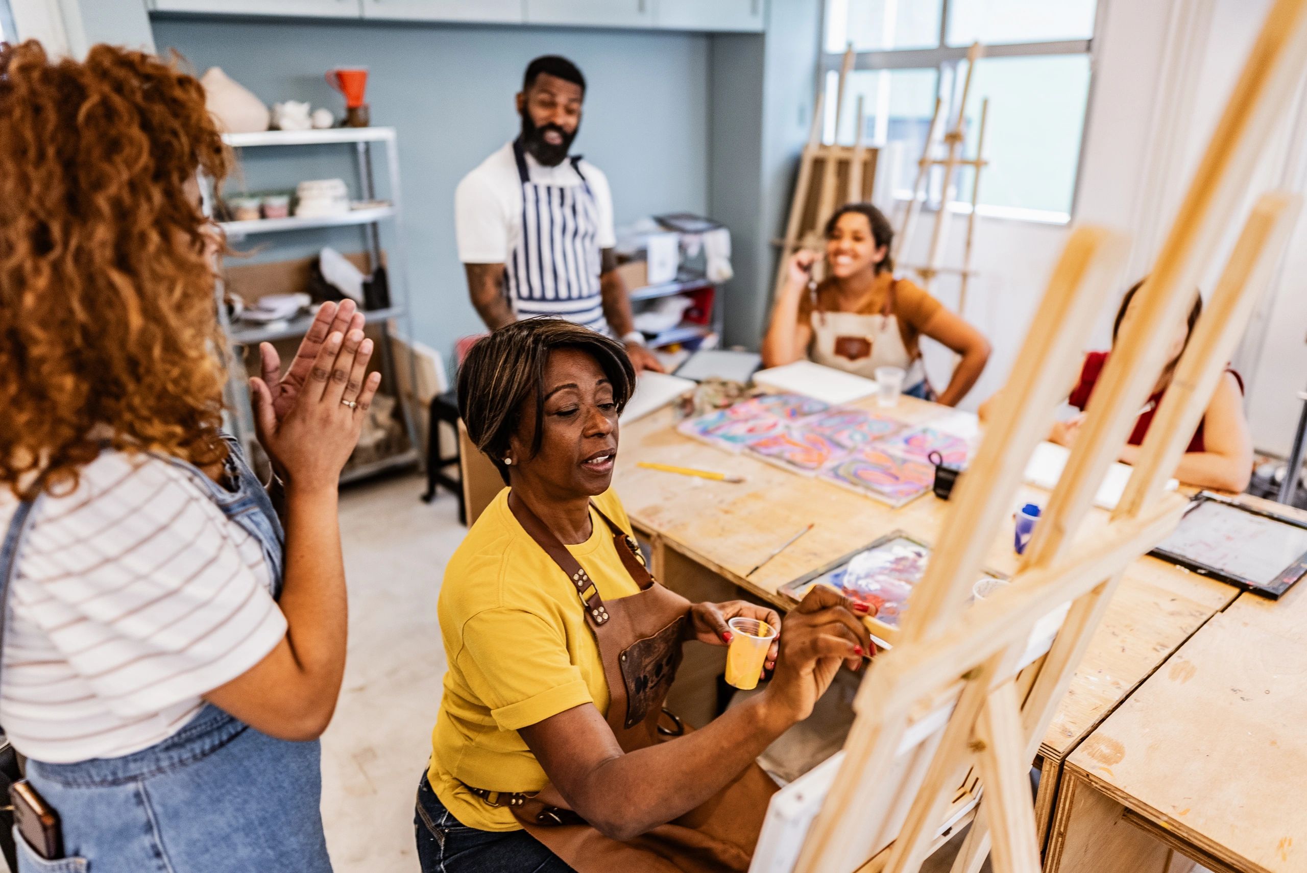 Teacher guiding participants in an art workshop