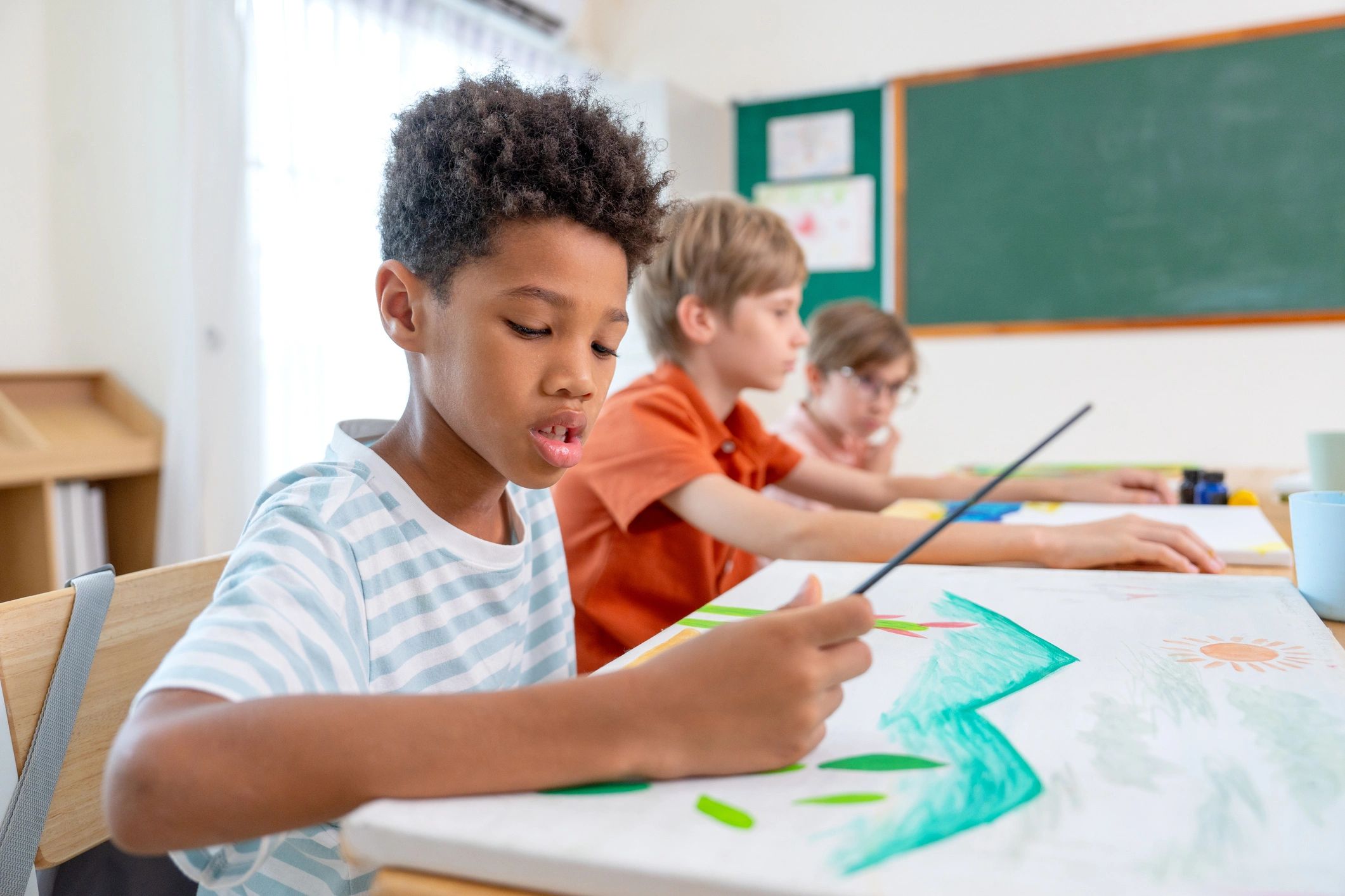 Student focused on creating artwork in a classroom