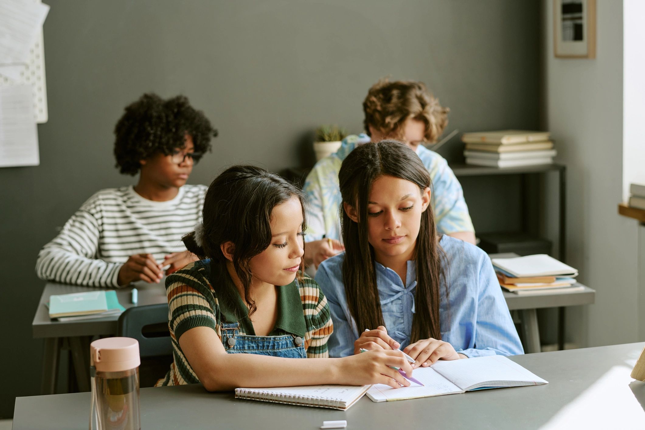 Diverse teenage students collaborating on schoolwork in a classroom